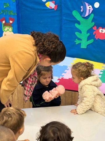 Educadora ajudando crianças durante uma atividade em sala