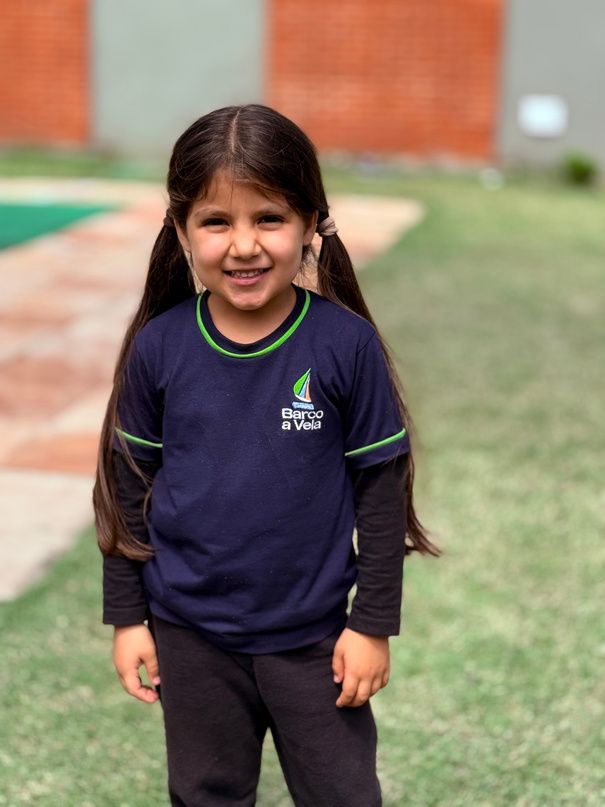 Menina sorrindo no pátio do Colégio